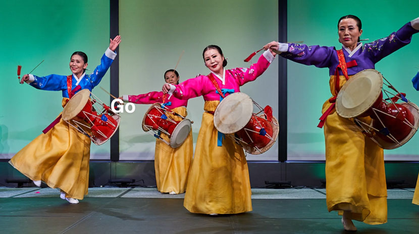 Video still of women holding drums in traditional folk dance