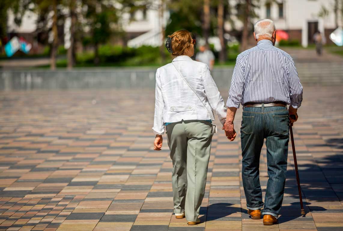An elderly couple going for a walk.