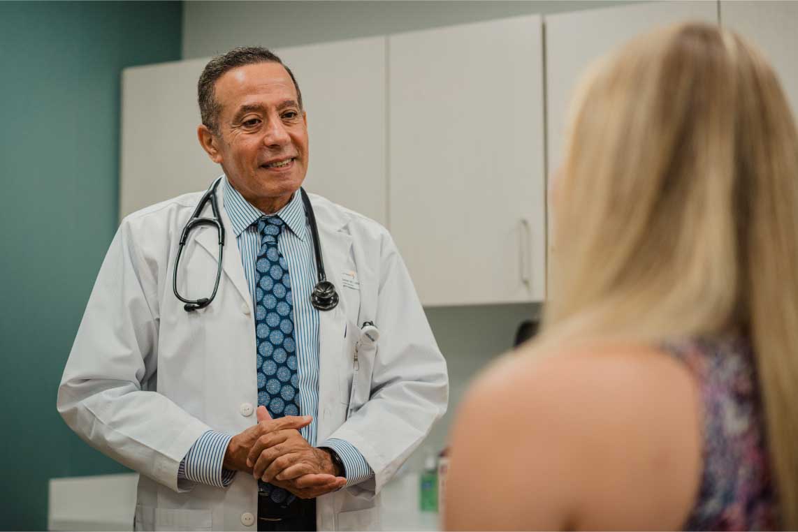 A doctor conversing with a patient during an exam.
