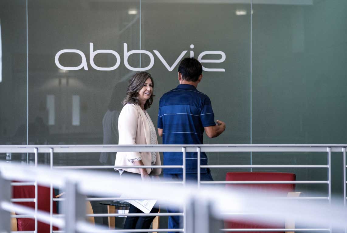 Two AbbVie employees walking and having a conversation on a walkway.